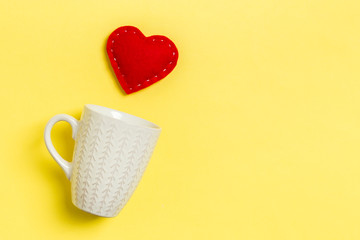 Top view composition of red hearts falling out from a cup on colorful background with copy space. Romantic relationship concept. St Valentaine's Day