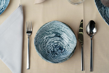 Details of a stylish table setting with textured ceramic dishes