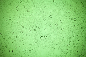 Rain droplets on green glass background, Water drops on green glass.