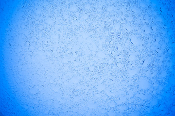 Rain droplets on blue glass background, Water drops on blue glass.