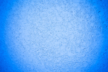 Rain droplets on blue glass background, Water drops on blue glass.