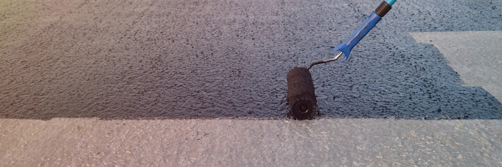 Worker applies bitumen mastic on the foundation