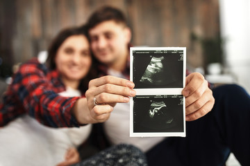 A young married couple awaiting a baby. Beautiful couple lying in the bedroom make plans for the birth of a baby. First child, postpartum, young family.
