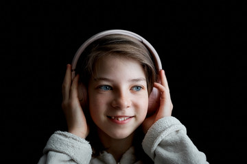 a teenage girl listens to music with headphones.