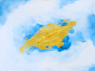 Abstract gold and blue watercolor paint on white paper background