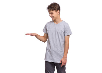 Portrait of happy teen boy showing hand something, isolated on white background. Series of photos - size concept. Handsome child looking away and smiling.