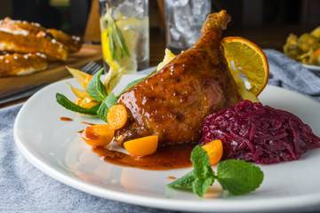 The duck leg on a rustic table in a cozy pub