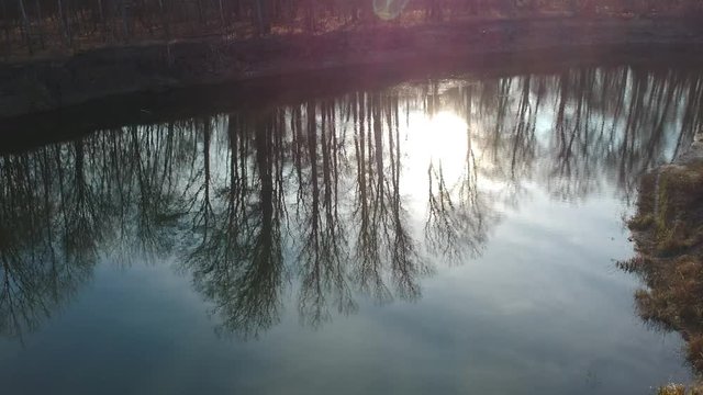 Flight over the forest river. Autumn. Blue water in the river. The sun.