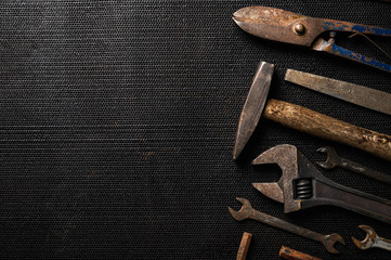 Old tools on black metal sheet background.