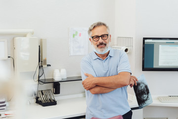 Confident doctor relaxing in his surgery