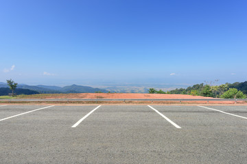 Empty parking lot against mountains and beautiful blue sky.