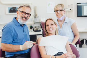 Obraz premium Smiling female patient posing with her dentist