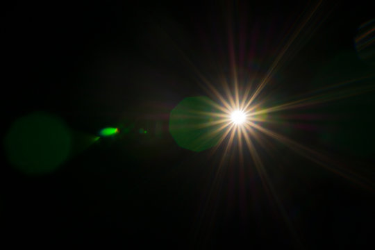 Abstract of sun lighting for background. Digital lens flare on black background. Easy to add overlay or screen filter for photos design. Sun, star, space, glow effect. 