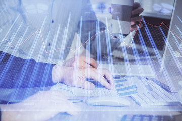 Multi exposure of chart with man typing on computer in office on background. Concept of hard work.