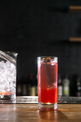 Pink and red Fresh colorful exotic alcoholic cocktail with lemon and ice in the bar. Colorful pink Soft drink with ice and decorated with dried flowers on the bar desk. Red colorful Mojito