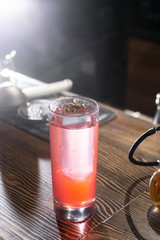 Pink and red Fresh colorful exotic alcoholic cocktail with lemon and ice in the bar. Colorful pink Soft drink with ice and decorated with dried flowers on the bar desk. Red colorful Mojito