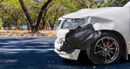 Front of white color car big damaged and broken by accident on city street parking can not drive any more. With copy space for text or design