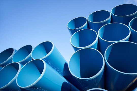 New and large blue pipes for sewage against a blue sky with text space