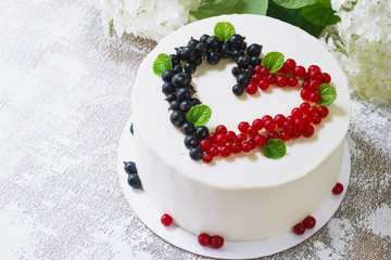 Round white cake with berries in the form of hearts, Valentine's Day, on white background. Picture for a menu or a confectionery catalog. Top view