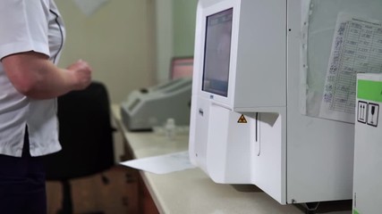 A female lab assistant is preparing blood tests. Modern medical technology. Mtdicinal lab. - Powered by Adobe