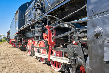 Fragment of the chassis of the old engine, wheels, springs, axle boxes, pistons and cylinders