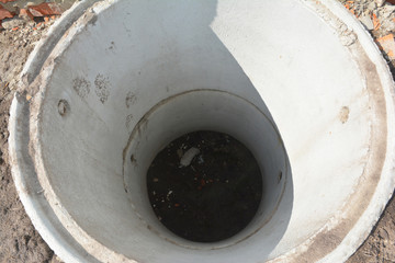 Installing concrete septic tank. Sewer tank hole installation outdoors top view