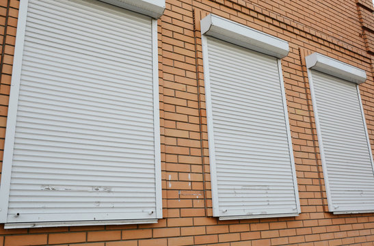 Brick house with metal roller shutters on the windows for protection