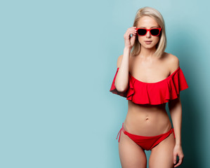 Beautiful blonde woman in red bikini and sunglasses - obrazy, fototapety, plakaty