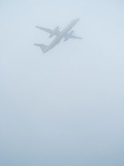 propeller airplane takes off in foggy weather