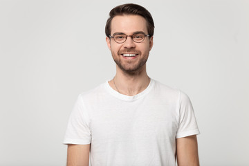 Happy smiling millennial guy wearing glasses head shot studio portrait.