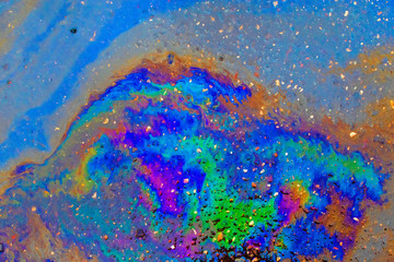 Bright multi-colored oil stain on the asphalt. Abstract background for lettering or design.