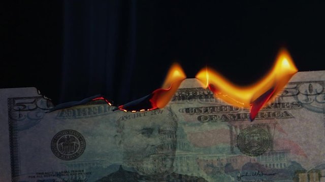 Burning 50 ten-dollar bill. Financial crisis. Money banknote on a black background, burning and Smoking, natural shooting
