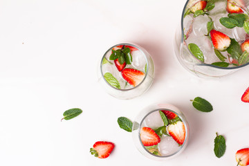 lemonade with mint, ice and strawberries and glasses