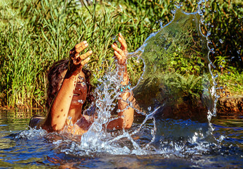 Fototapeta na wymiar beautiful woman in lake splashes water and painting effect.