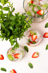 drink with ice, strawberries and mint on a white background top view