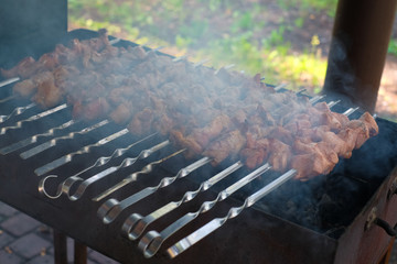 Raw kebab grilling on metal skewer. Meat roasting at barbecue with vegetables. BBQ fresh beef chop slices. Traditional eastern dish, shish kebab. Grill on charcoal and flame, picnic, street food