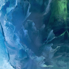 Background of blue  peony  flower    in ice   cube with air bubbles.