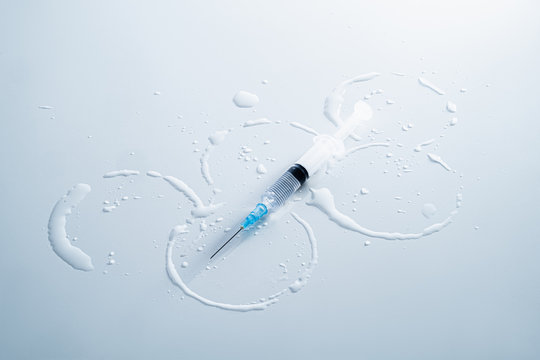 Water circles shaping the symbolf of the olympic games and a syringe. Concept of doping in sports, using drugs for performance, or corruption in sports