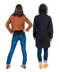 Back view of couple couple in winter jackets pointing.
