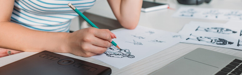 panoramic shot of illustrator drawing sketches in studio