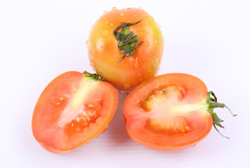 Tomatoes with water drops Tomato pieces isolated on white background