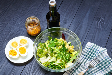 Vegetarian salad mix of fresh vegetables and boiled chicken eggs on a wooden background. Healthy and wholesome organic food, diet, proper nutrition concept.