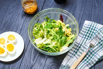 Vegetarian salad mix of fresh vegetables and boiled chicken eggs on a wooden background. Healthy and wholesome organic food, diet, proper nutrition concept.