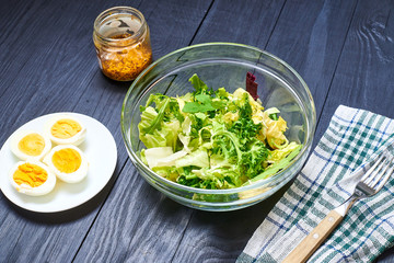 Vegetarian salad mix of fresh vegetables and boiled chicken eggs on a wooden background. Healthy and wholesome organic food, diet, proper nutrition concept.