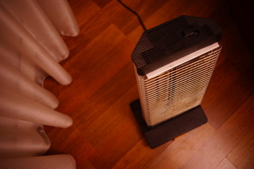 Retro electric heater Ugolek in the room on parquet floor