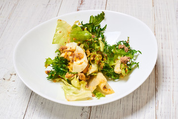 Mix salad of fresh vegetables, tuna, eggs on a white wooden background. Healthy and wholesome organic food, diet, proper nutrition concept.