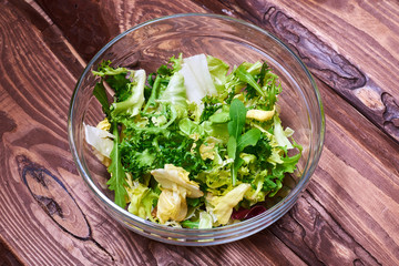 Vegetarian salad mix of fresh vegetables on a wooden background. Healthy and wholesome organic food, diet, proper nutrition concept.
