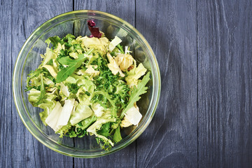 Vegetarian salad mix of fresh vegetables on a dark wooden background. Healthy and wholesome organic food, diet, proper nutrition concept.