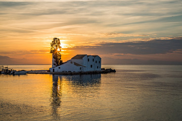 Obraz premium Early morning sunrise view of famous Vlachernа monastery, Pontikonissi or mouse island and fisherman boats in Halikiopoulou lagoon. Kanoni, Corfu island, Greece.