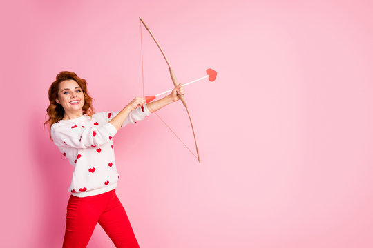 Portrait of her she nice attractive lovely pretty cute confident amorous cheerful cheery glad wavy-haired girl angel shooting arrow match making soulmate isolated on pink pastel color background